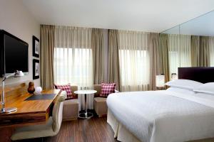 爱丁堡喜来登大酒店&SPA的酒店客房设有一张大床和一张书桌。