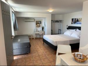 菲罗斯特法尼阿罗尼亚公寓酒店的一间卧室配有一张床、一张桌子和一张桌子