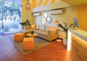 浦那Bloom Hotel - Magarpatta的带沙发和橙色椅子的客厅