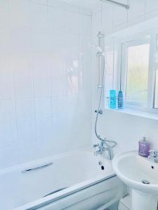 The HydeWonderful Apartment in London的带淋浴和盥洗盆的白色浴室