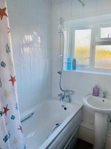 The HydeWonderful Apartment in London的白色的浴室设有浴缸和水槽。
