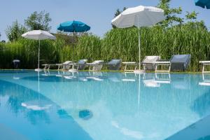 沃尔特湖畔韦尔登弗洛拉别墅酒店的一个带桌子、遮阳伞和椅子的游泳池