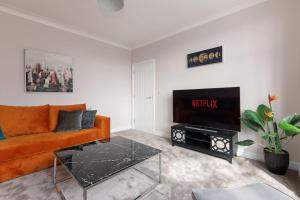 谢菲尔德Home away from home的客厅配有橙色沙发和电视