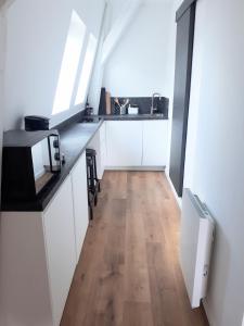 阿拉斯"Au pied du Beffroi" - Superbe emplacement的厨房铺有木地板,配有白色橱柜。