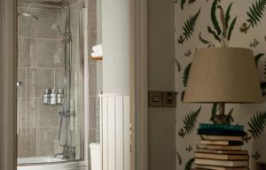 布莱克本The Millstone, Mellor的带淋浴、灯具和书籍的浴室