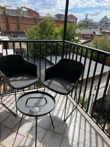 哈尔科夫Sumskaya Apartment Lux的阳台配有2把椅子和1张桌子