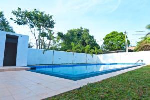 阿努拉德普勒Thinaya lake resort的白色围栏旁的游泳池
