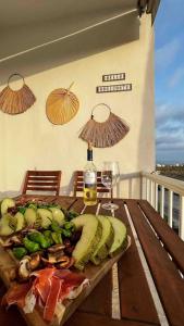 多列毛利诺斯NIEUW: Bello Horizonte, house by the sea的一张木桌,上面放着一盘食物和一瓶葡萄酒