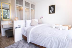 卡马拉海滩Oceana B24的白色卧室配有一张带白色床单的大床