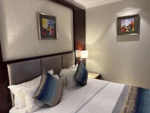 卢萨卡Grand Palace Hotel Lusaka的酒店客房配有带白色床单和枕头的床。