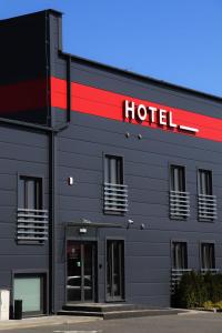 沃姆扎M&W Hotel Wronowski的一边有红色标志的酒店