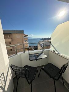 萨兰达Villa Idrizi的阳台配有两把椅子,享有海景。