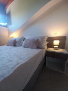 RicciaIl Riccio home & relax的卧室配有一张带灯的白色大床