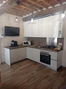 卢卡Monolocale Lucca PellegriniLittleHouse的厨房配有白色橱柜和炉灶烤箱。