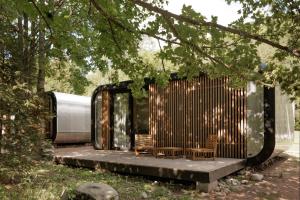 什平德莱鲁夫姆林Chalets & Apartments - Base Camp Medvědín的木头房子,两把椅子和树木