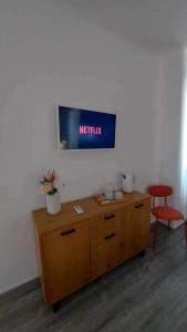 塞萨洛尼基Unique Experience Apartment’s的木柜上方墙上的电视机