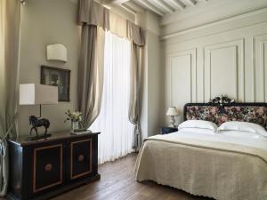 科尔托纳Villa di Piazzano - Small Luxury Hotels of the World的一间卧室设有一张床和一个大窗户