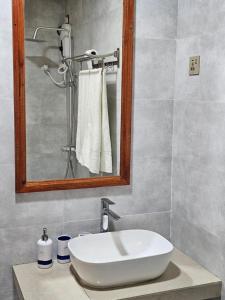 马米基里White Sand Inn的浴室设有白色水槽和镜子