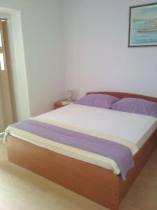 巴什卡沃达Apartmani Carević的一间卧室配有一张带紫色床单的大床