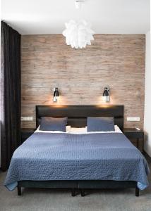 卢布林格罗兹卡街20号酒店的一间卧室配有一张带蓝色棉被的床
