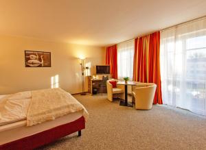瓦伦Hotel Zur Sonne的配有一张床、一张桌子和一张桌子的酒店客房