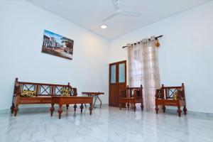 阿努拉德普勒Thinaya lake resort的一间房间,配有三把椅子和一张画面墙