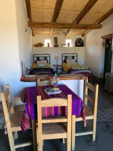 卡奇Cabaña Los Girasoles Cachi Salta的一间带桌子和两张床的用餐室