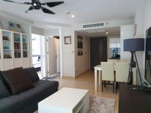 芭堤雅市中心Centara Avenue 2 Bedrooms Pool View的客厅配有沙发和桌子