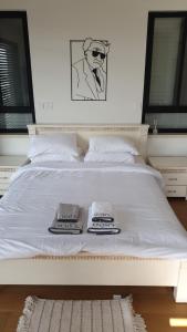 米德希特本-古里安נס הבריאה的一张白色的床,上面有两条毛巾