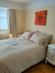 伯肯黑德Linksway House的卧室设有一张白色大床和一扇窗户。