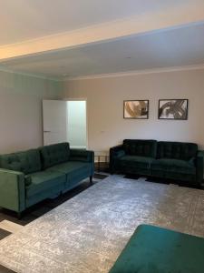 奥本Hillview的客厅配有两张绿色沙发和一张桌子