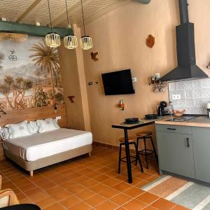 瓜达卢佩ANJ ESTUDIO TEMPLETE的一间卧室配有一张床铺和一张桌子,还设有一间厨房