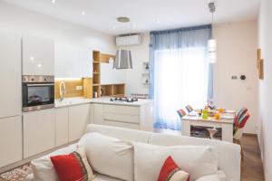 罗马Cozy flat with terrace at Trastevere train station的一间带白色沙发的客厅和一间厨房