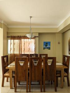 圣斐利-银港Espacioso apartamento en Puerto Plata的一间带木桌和椅子的用餐室
