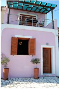 瓦西Odysseos St. Loft的前面有两棵盆栽树的粉红色建筑
