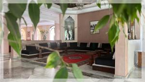 阿尤恩Hotel Al Massira的大楼内一个带沙发和椅子的大堂