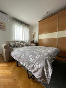 萨格勒布Lanište - Prelijep stan, balkon, wifi + besplatan parking的一间卧室配有一张大床和木制床头板