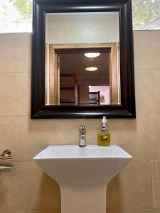 阿克拉LA SUNSET的浴室设有白色水槽和镜子
