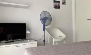 托尔博莱Appartamenti Nataly的客房设有风扇、电视和床。