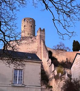 希农Le gargantua, appartement à 500m du château的一座城堡,在一座建筑的顶部有一座塔