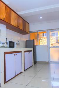 杜阿拉Appartement Cosy 3 bonapriso的厨房配有白色橱柜和白色瓷砖地板。