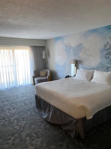 雷纳姆波士顿莱茵汉姆万怡酒店 的酒店客房带一张大床和一把椅子