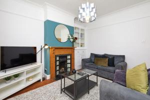 莱斯特Timeless Elegance 4-Bed Victorian Charm的带沙发和电视的客厅