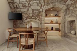 罗希姆诺Soleil boutique house with terrace的一间设有桌椅和石墙的用餐室