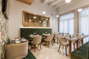 波尔图Ribeira Douro Hotel的一间带桌椅和镜子的用餐室