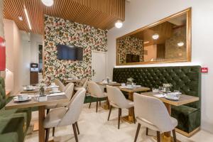 波尔图Ribeira Douro Hotel的一间带桌椅和电视的用餐室