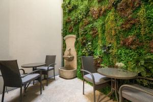 波尔图Ribeira Douro Hotel的配有桌椅和绿色墙壁的客房