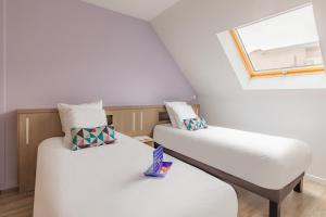 波城Appart'City Confort Pau Centre的带窗户的客房内的两张床