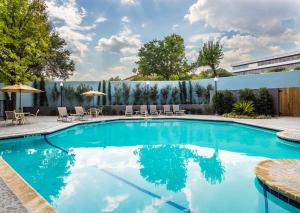 奥斯汀奥斯汀西北部希尔顿逸林酒店 - 树木园的一个带椅子和围栏的游泳池