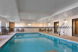 伯明翰伯明翰机场区汉普顿套房酒店的一座配有桌椅的酒店游泳池